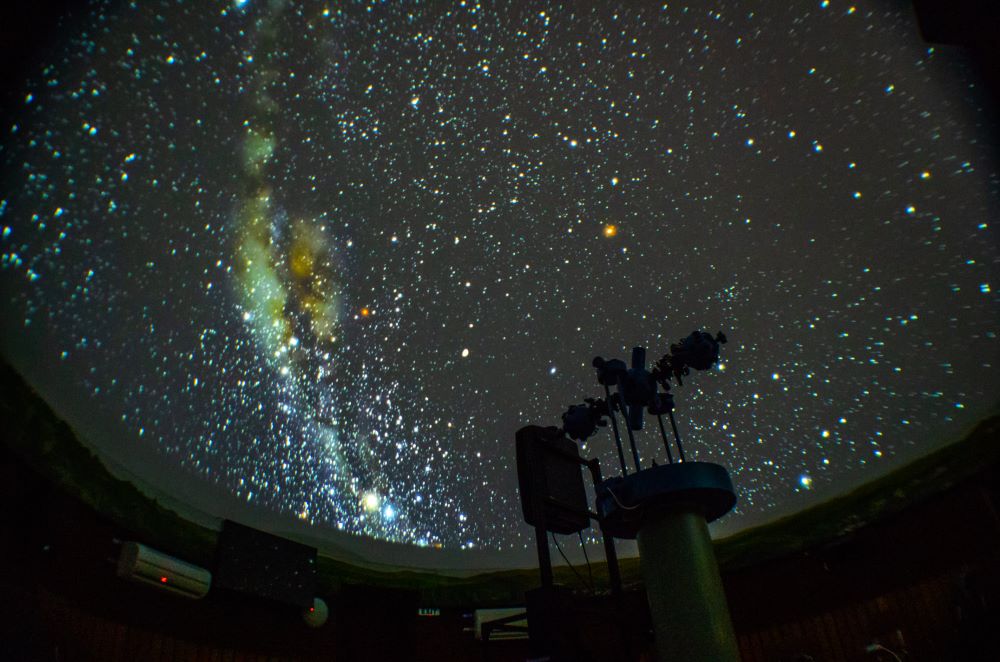 Куполна зала на Астрономическа обсерватория и планетариум в Габрово, с проекция на звездно небе и планетариумна техника на преден план