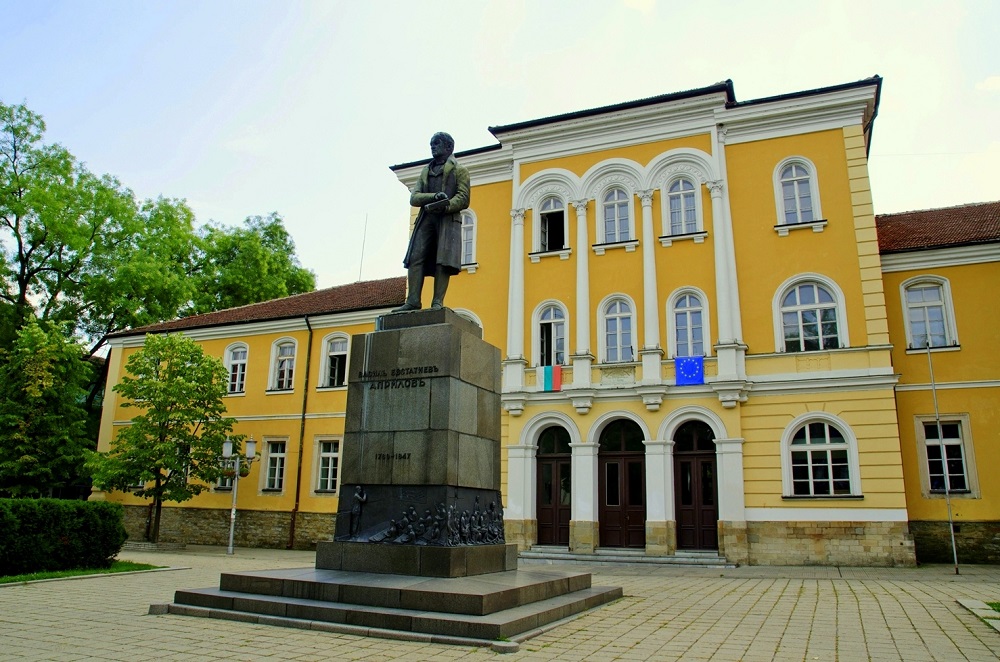 Паметник на Васил Априлов пред Национална Априловска гимназия в Габрово, фасада на историческата училищна сграда, цветна снимка
